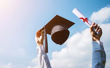 Hands hold up a graduation cap