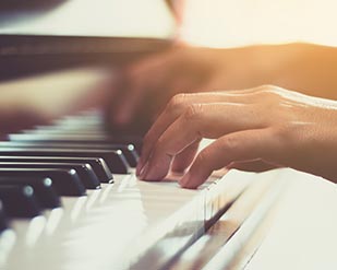 Close-up of person playing a piano