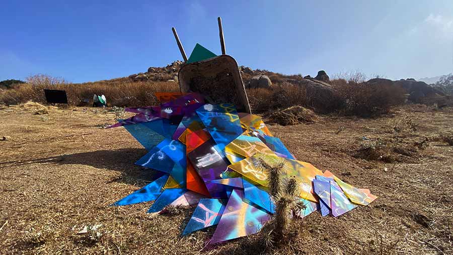 Making Refuge installation showing a tipped wheelbarrow overflowing with colorful broken plastic