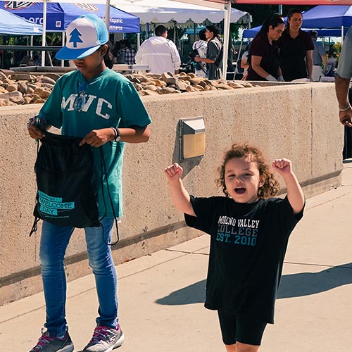 A child cheers while wearing a MVC shirt