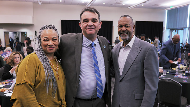 President Besikof stands with community leaders at a scholarship breakfast