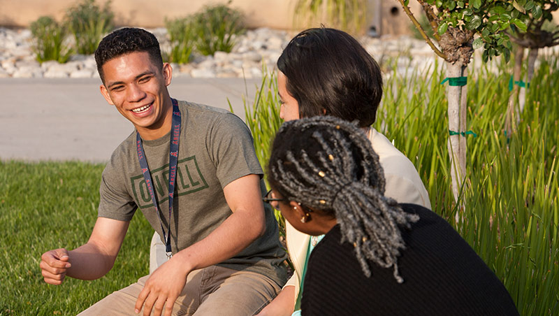 A male student laughs with friends