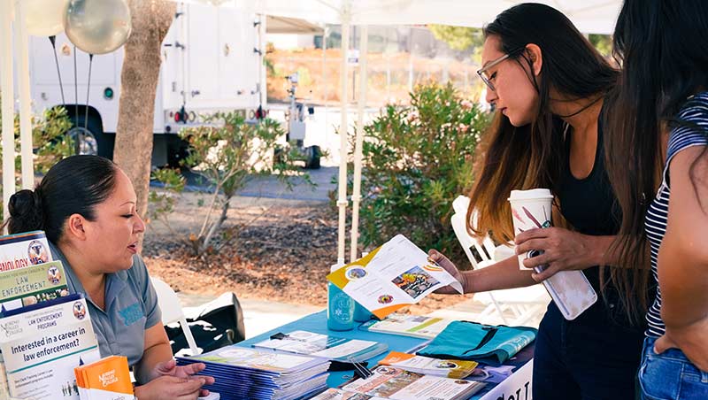 A prospective student speaks with a School of Public Safety counselor