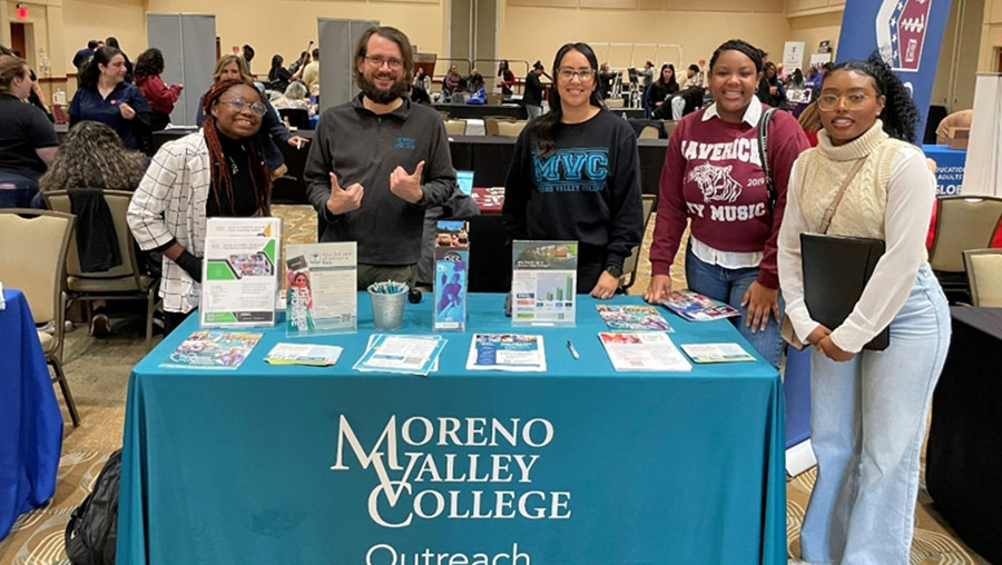 MVC's outreach team and student leaders pose for a photo at an MVC branded table