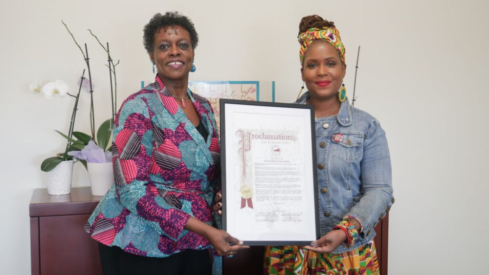 Interim President FeRita Carter, Ph.D. and Professor Melanie Lindsay, Ph.D. hold up a framed proclamation