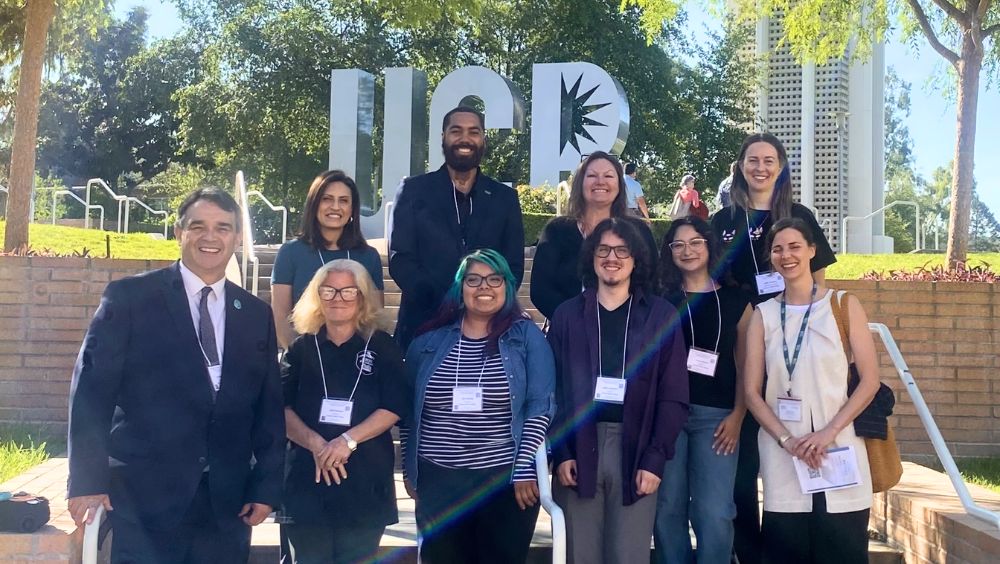 College leaders, faculty, and MVC Honors students pose for a group photo in front of the UCR monogram sculpture at the UCR campus
