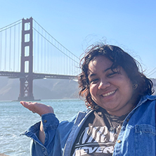 Portrait of graduate Ariana Sicarios in front of the Golden Gate Bridge in San Francisco