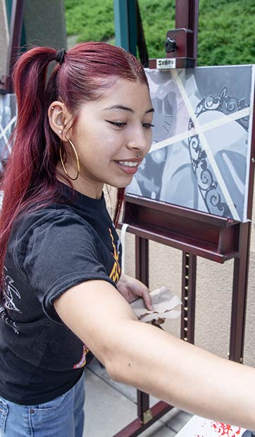 A student paints in black and white during art class