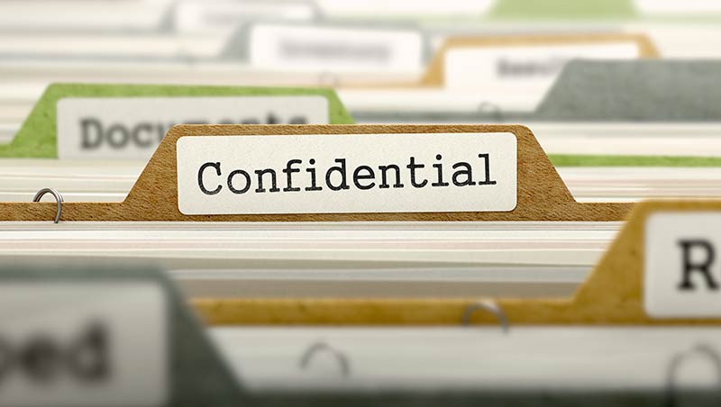 Close up of file folders with one label stating Confidential