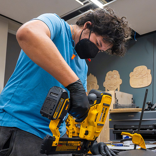 A student uses woodworking equipment