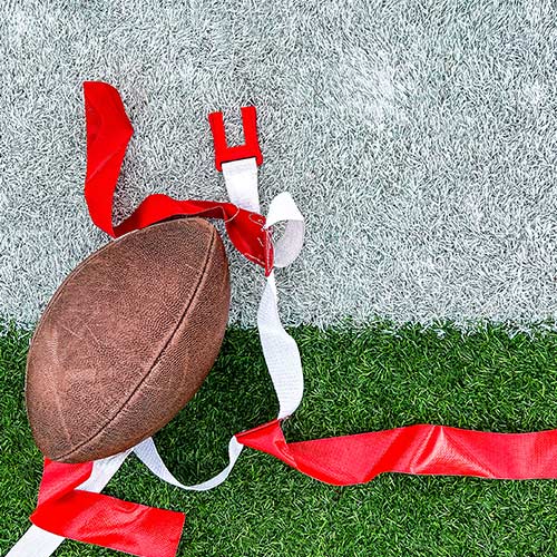 Top down view of a football on turf with flag belt