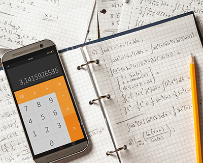 Notebook of calculus homework on graph paper with a phone calculator