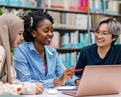 Multiethnic group of students sitting in a library and studying together