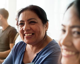 A hispanic adult smiles during a support group session