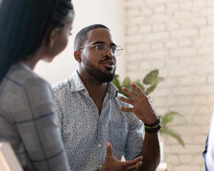 An African American man speaks to a group