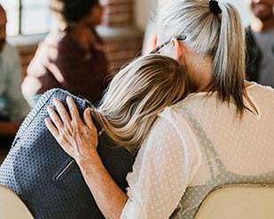 Two attendees to a support group comfort each other