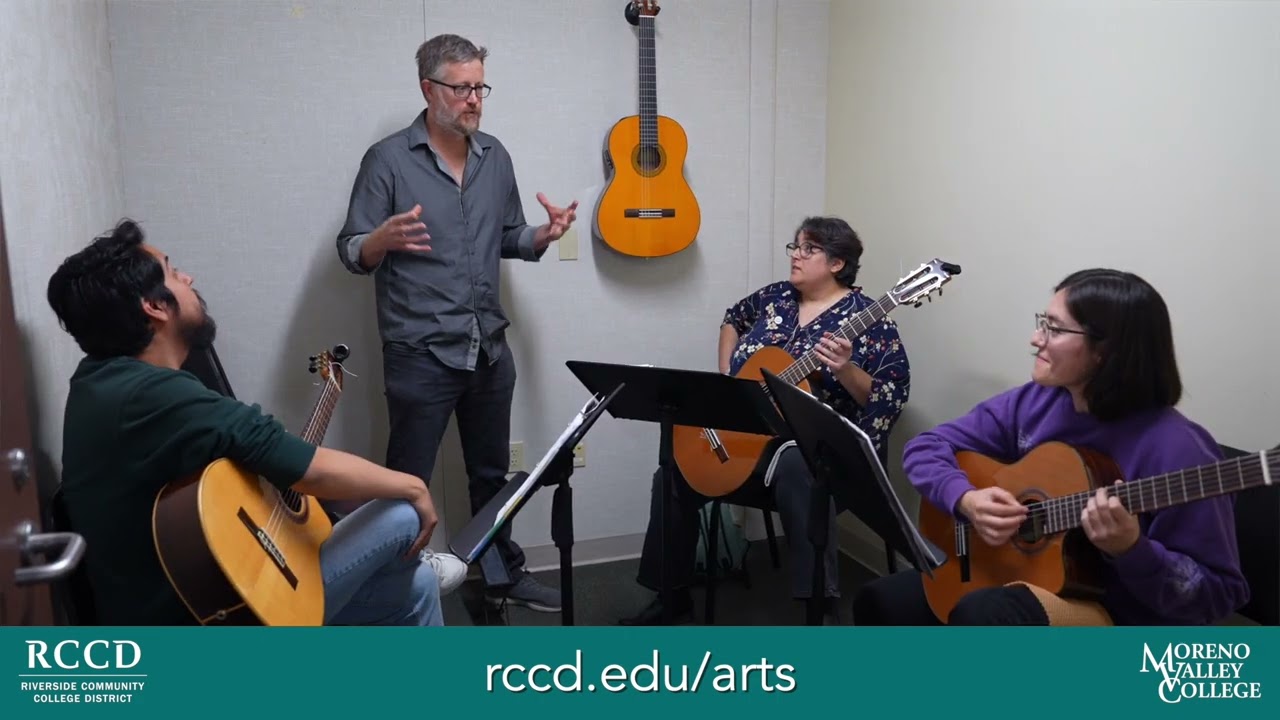 Thumbnail of Professor McNaughton explaining guitar to 3 students